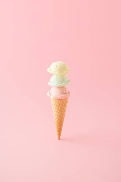 istock Ice cream with three scoops in a cone placed vertically on pink background. Minimal summer concept. 1397409392