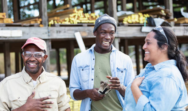 Multiracial group of workers at lumberyard, laughing