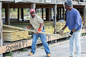 istock Two African-American men stacking wood at lumberyard 1397409539