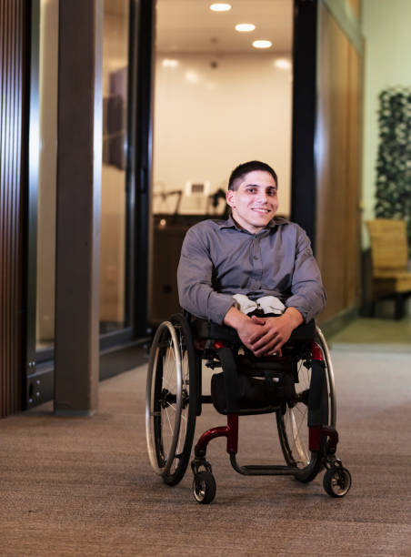 istock Young man in wheelchair, in office corridor 1397410234