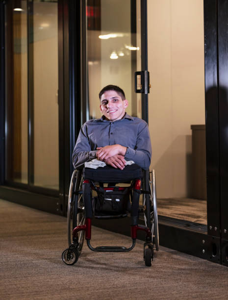 istock Young man in wheelchair, in office corridor 1397410272