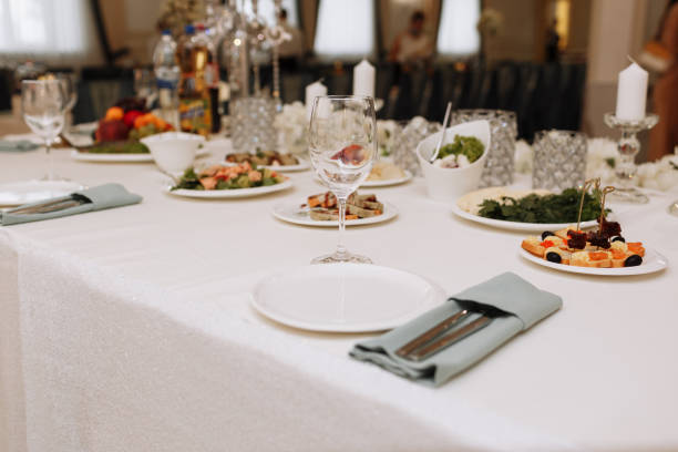 istock Empty glass set in restaurant. wedding, decor, celebration, holiday concept - romantic table setting with white tablecloth, plates, crystal glasses 1397411574