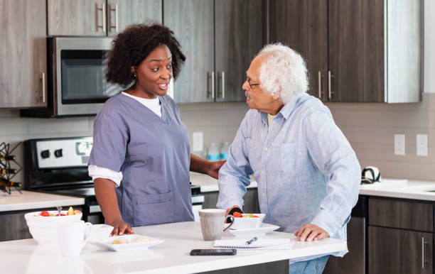 istock Home caregiver helps senior man in kitchen 1397412558