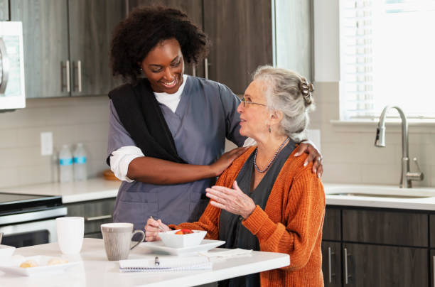가정 간병인은 노인 여성이 건강한 간식을 먹을 수 있도록 도와줍니다. - senior adult nursing home eating home interior 뉴스 사진 이미지
