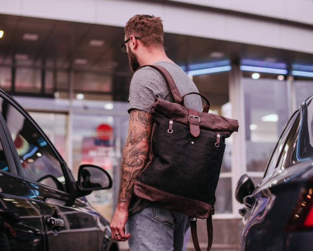 istock Handsome man with close up canvas and leather backpack. Rear view 1397413645