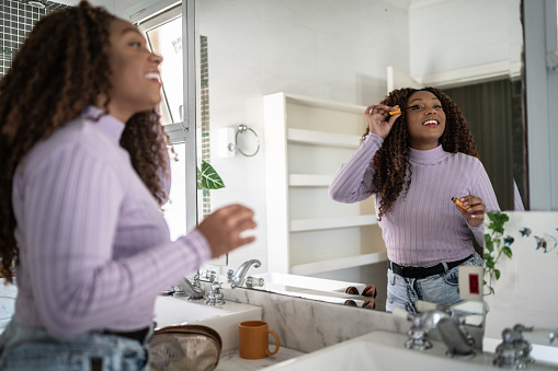 Young woman doing make up at home