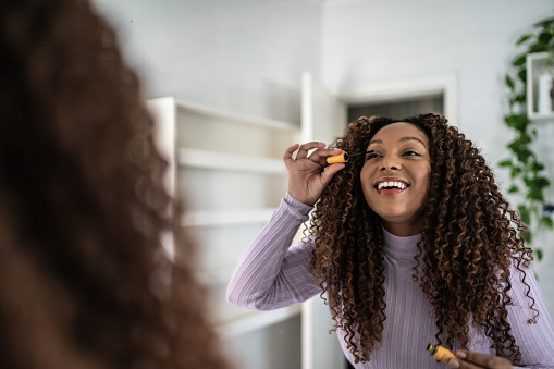 Young woman doing make up at home