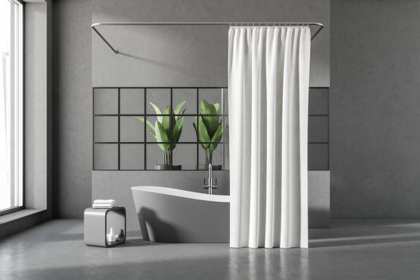 istock Grey bathroom interior with bathtub and curtain, plant and window 1397414889