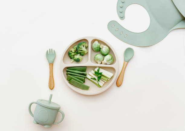 Baby food flat lay. Variation of fresh green vegetables. Healthy vegan food with vitamins, minerals. First children feeding concept. Top view stock photo