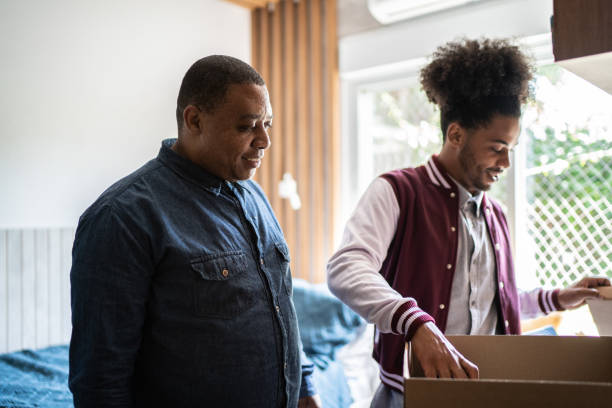 istock Father helping son packing to move out from parent's home 1397414955