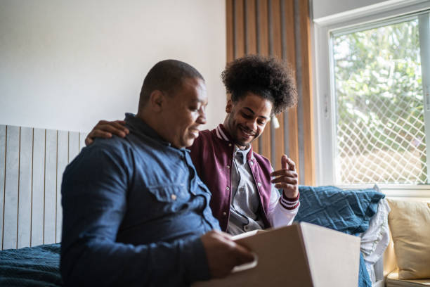 istock Father helping son packing to move out from parent's home 1397414984