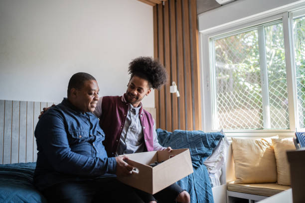 istock Father helping son packing to move out from parent's home 1397414986