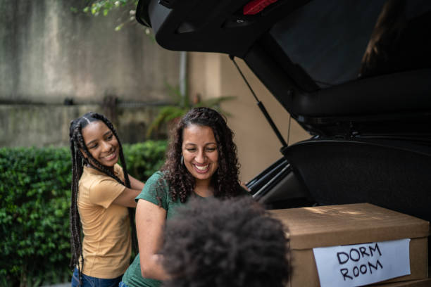 istock Mother and daughter putting moving boxes into car trunk 1397415547