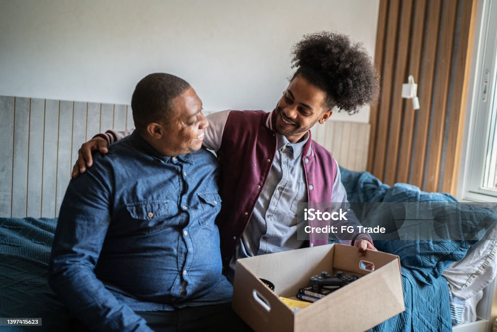Father helping son packing to move out from parent's home College Dorm Stock Photo