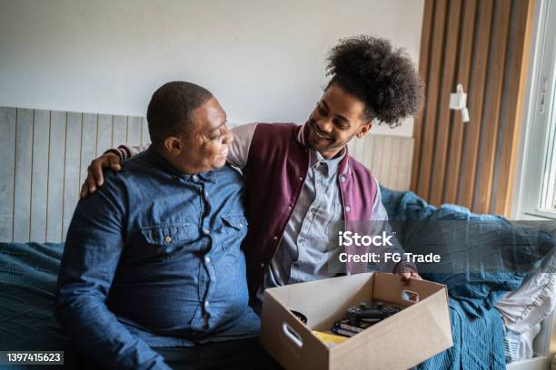Father Helping Son Packing To Move Out From Parents Home Stock Photo - Download Image Now