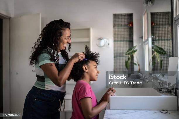 Mother Combing Daughters Hair At Home Stock Photo - Download Image Now - Mother, Child, Hair