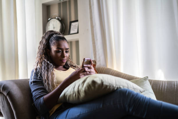 istock Young woman using the mobile phone at home 1397417161