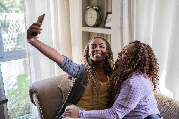 istock Female friends taking selfie using the mobile phone at home 1397417165