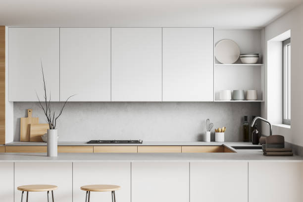 istock Light kitchen interior with island and seats, shelves and decoration, window 1397417500