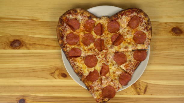 istock Heart shaped pizza for valentine's day. The camera approaches the pizza. View from above. 1397419700