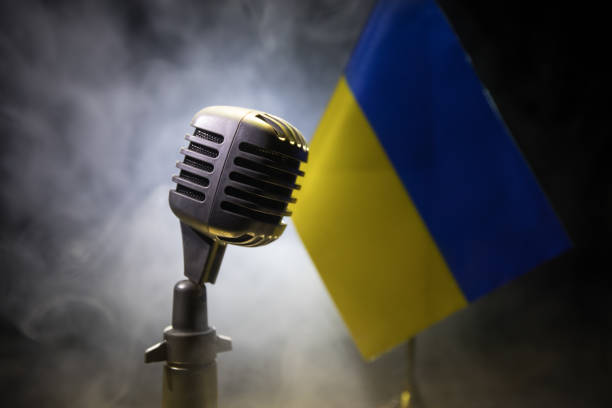 istock Microphone on a background of a blurry flag Ukraine close-up 1397420842