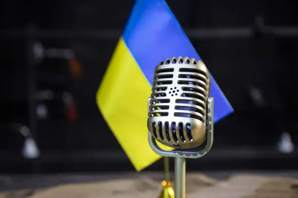 Photo of Microphone on a background of a blurry flag Ukraine close-up