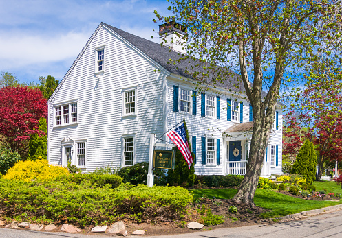 Sandwich, Massachusetts, USA- Trees and shrubs blossom with springtime colors around the old Newcomb Tavern (1693) in Sandwich, Massachusetts.  This historic bed and breakfast is centrally located in the oldest town on Cape Cod.