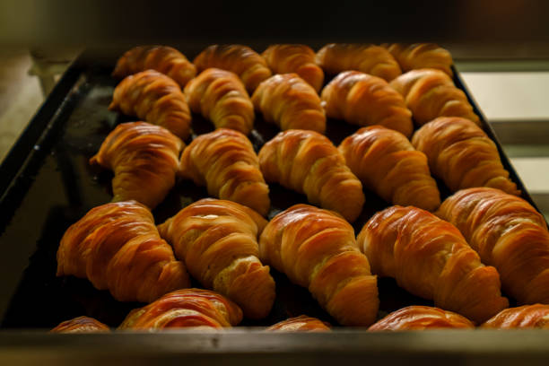 Fresh baked croissants on white table. Closeup.