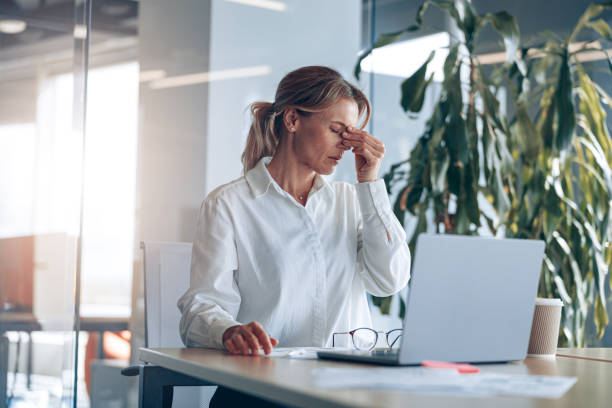 istock Tired lady boss with headache working on laptop at her workplace at modern office 1397430064
