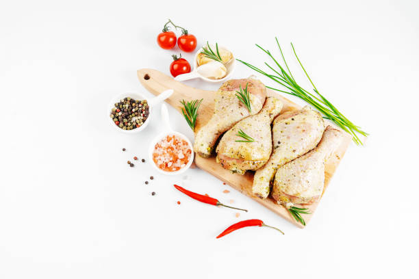 BBQ drumstick.Semifinished. Fast cooking.Chicken drumstick marinated with fresh leaves and spices on a kitchen wooden board. Copy space. Raw chicken legs.