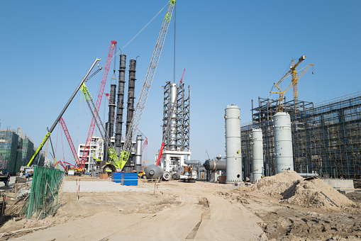 Storage tanks and cranes on the construction site of the chemical plant under construction