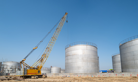 Storage tanks and cranes on the construction site of the chemical plant under construction