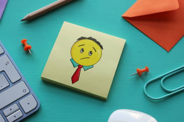Business emoji on adhesive note paper with computer keyboard