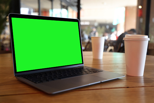 Mock-up Green Screen Laptop Standing on the Desk in the Cafe