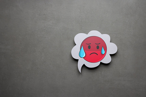 Sadness emoji on speech bubble with gray background