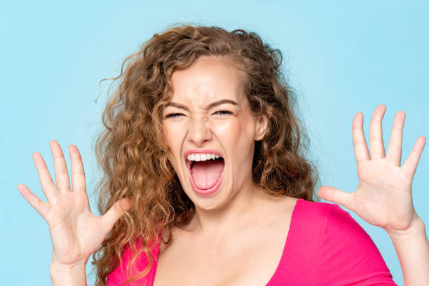 istock Shocked Caucasian woman screaming with open hands in isolated light blue color studio background 1397444525