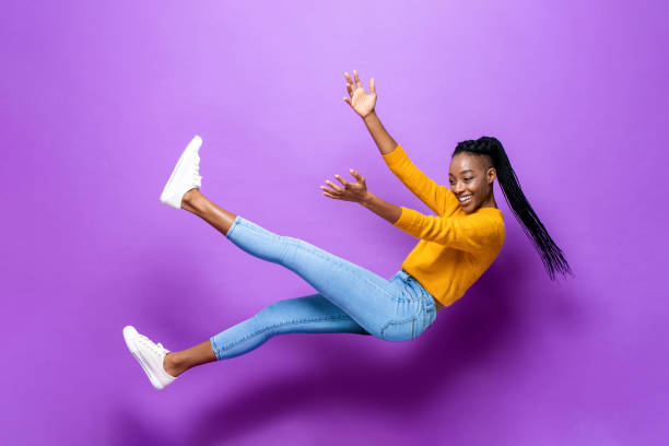Delighted black woman falling in studio stock photo