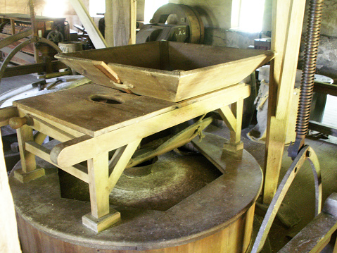 Interior of grist mill showing the hopper for funneling and guiding grain into the grind stone area.  Taken at historic Waterloo Village, NJ.