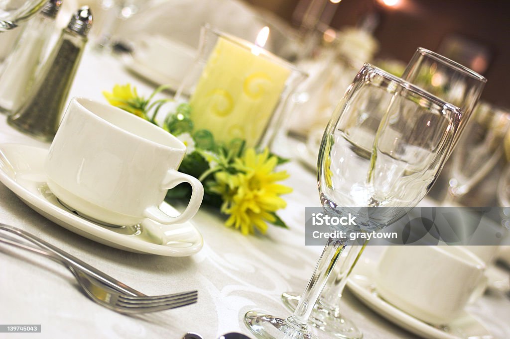 A formal dinner setting with yellow flowers A table laid out for fine dining Buffet Stock Photo