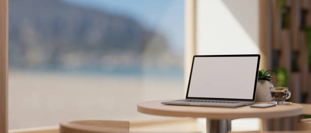 istock Coffee shop seating space with a laptop computer mockup on coffee table near the window 1397452679