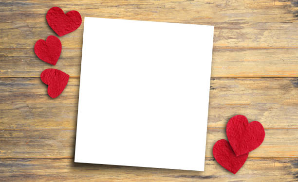 istock Red paper heart and paper on wood table. 1397453862