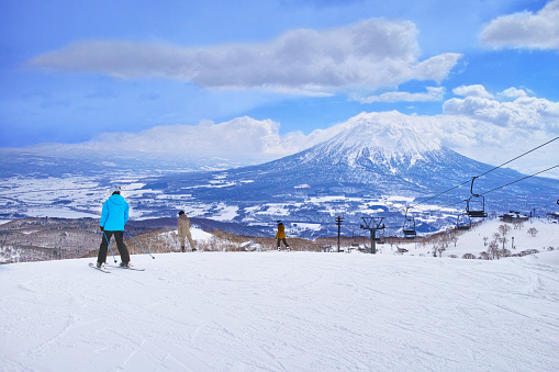 Niseko, Hokkaido, Japan --March 22, 2022: Niseko ski resort for spring skiing, skiers and snowboarders before skiing looking at the skiing course from now on.