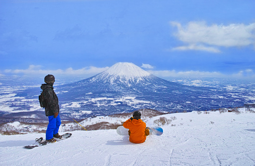 Niseko, Hokkaido, Japan --March 23, 2022: Spring skiing Niseko ski resort, snowboarders before skiing overlooking Mt. Yotei