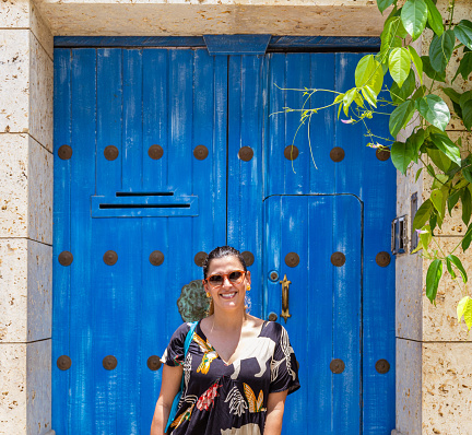 tourist latina woman standing at a door and looking at camera in Cartagena Colomba