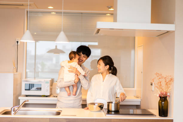 mama kocht in der küche mit papa und baby - two parent family indoors home interior domestic kitchen stock-fotos und bilder