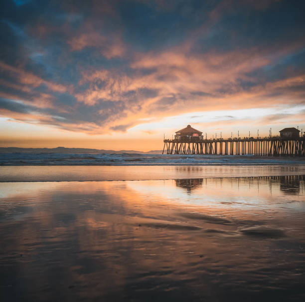 pôr do sol sobre huntington beach pier california - huntington beach - fotografias e filmes do acervo