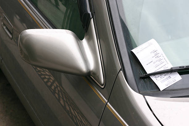 A silver car with a parking ticket on the window stock photo