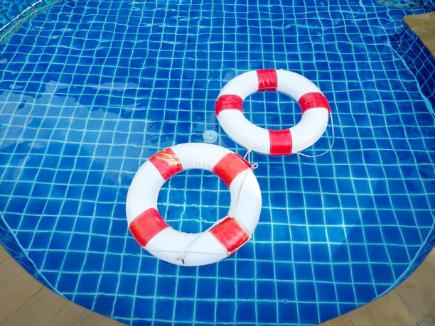 istock White life buoy on water surface at swimming pool. 1397461278