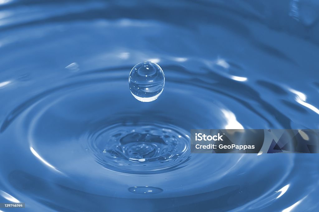 Water Drop High-speed photo of a water drop frozen in time after it has impacted and rebounded a body of water. Activity Stock Photo