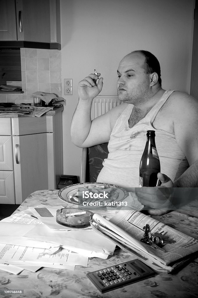 after lunch man in dirty clothes is smoking a cigarette after lunch Prepared Potato Stock Photo